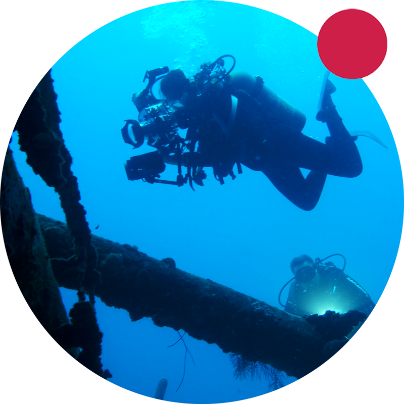 Scuba divers looking at wreckage with camera